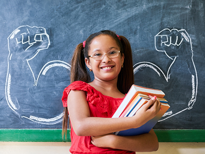 hispanic school girl with muscular arms drawn on blackboard