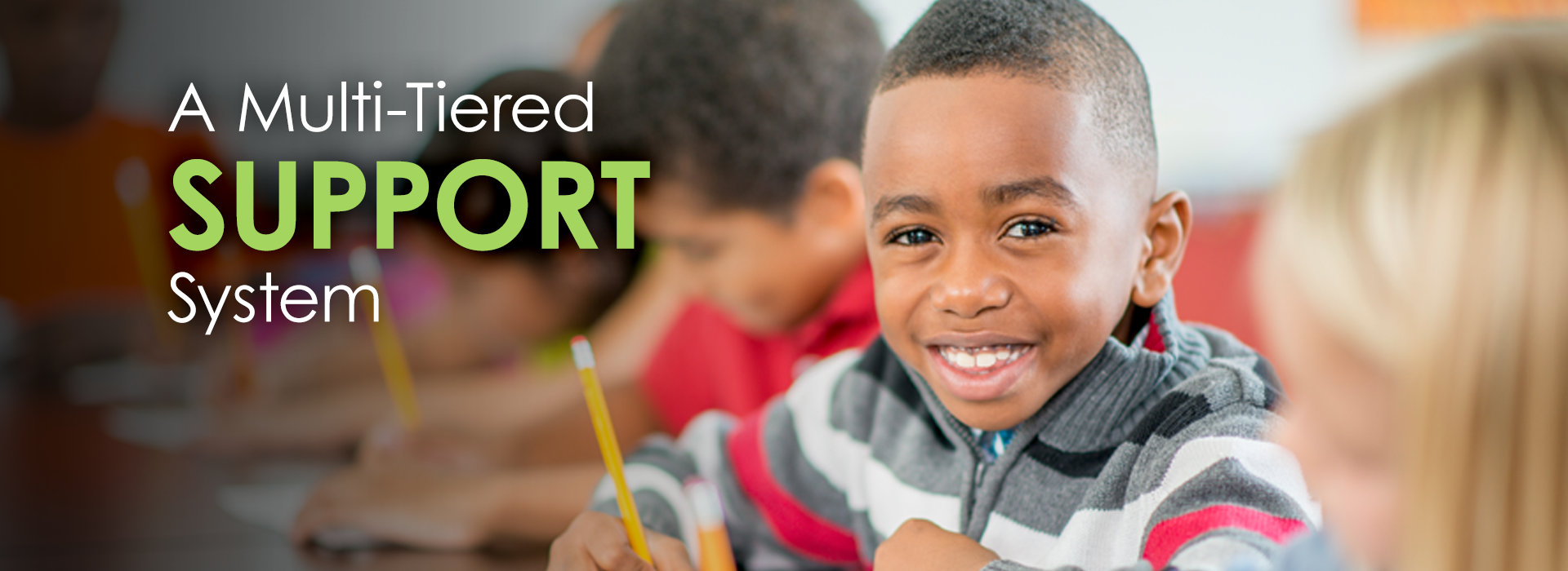 Happy boy in classroom with words 'A multi-tiered support system'